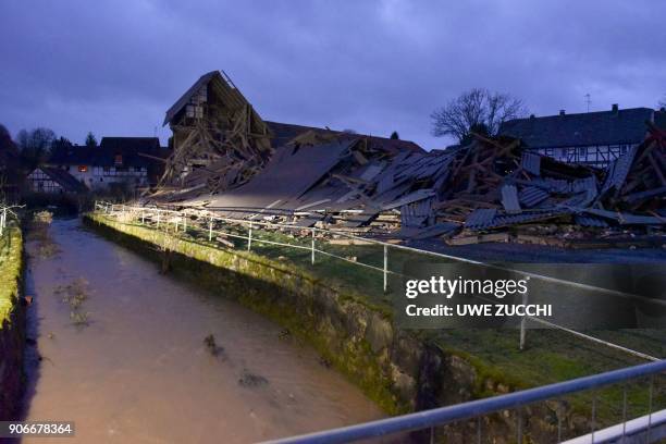 Picture taken on January 18, 2018 shows rubble after a barn collapsed at a farm due to strong winds in Meimbressen, central Germany. - Violent gales...