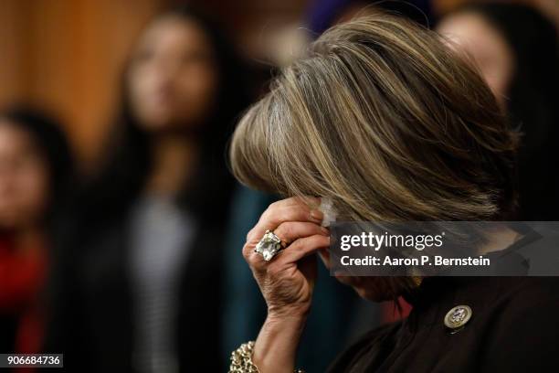 Rep. Michelle Lujan Grisham wipes her eyes at a press conference calling for the passage of the Dream Act at the U.S. Capitol January 18, 2018 in...