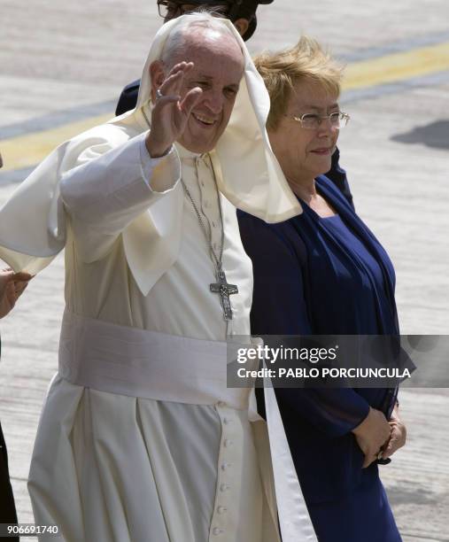 Pope Francis waves next to Chilean President Michelle Bachelet as he gets ready to board the plane to leave the northern Chilean city of Iquique,...