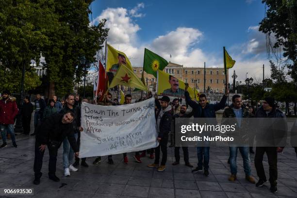 Kurdish in Athens, hold a portrait of Kurdistan Worker's Party jailed leader Abdullah Ocalan and flags, during a protest in support of Afrin, in...