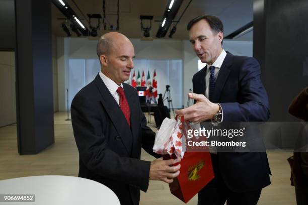 Bill Morneau, Canada's finance minister, right, hands Jose Antonio Gonzalez Anaya, Mexico's finance minister, a gift during a joint news conference...