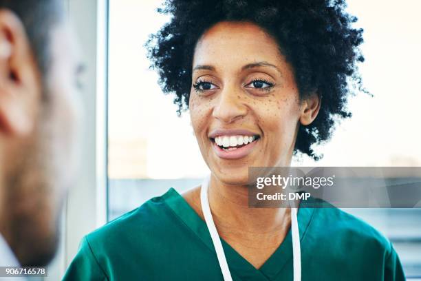 young female medical professional talking with colleague in clinic - doctor close up stock pictures, royalty-free photos & images