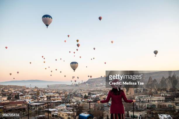 woman watching hot air balloons in cappadocia - cappadocia hot air balloon stock-fotos und bilder