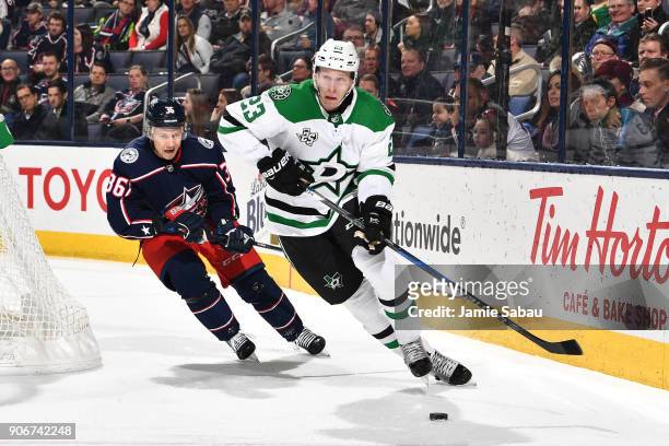 Esa Lindell of the Dallas Stars skates the puck away from Jussi Jokinen of the Columbus Blue Jackets during the first period of a game on January 18,...