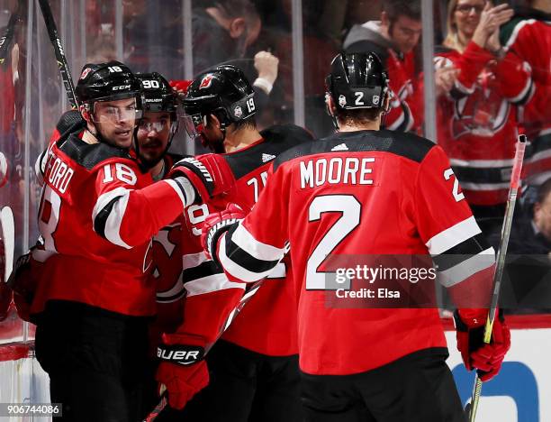 Drew Stafford of the New Jersey Devils is congratulted by teammates Travis Zajac, Marcus Johansson and John Moore after he scored a goal in the first...