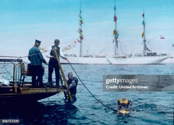 Diver diving in the ocean, 1920s.