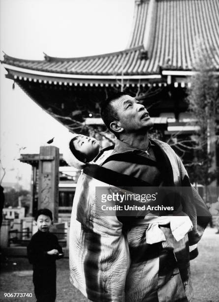 Father and his children visiting Asakusa Kannon temple sensoji at Tokyo, Japan 1960s.