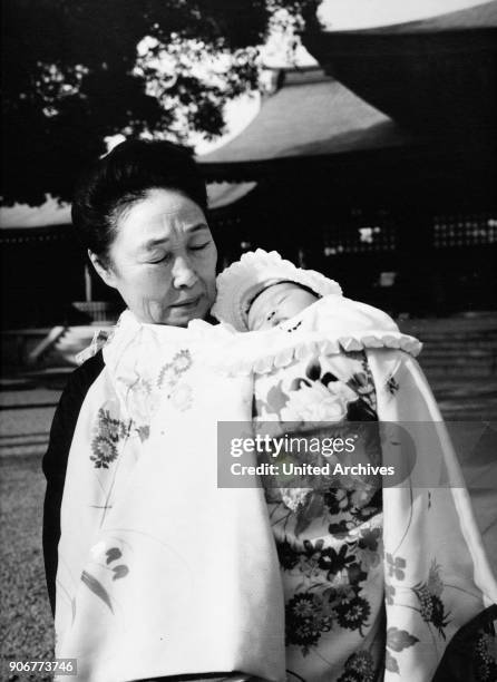 Grandmother bringing her grandchild to be baptised to Meiji shrine at Kyoto, Japan 1960s.