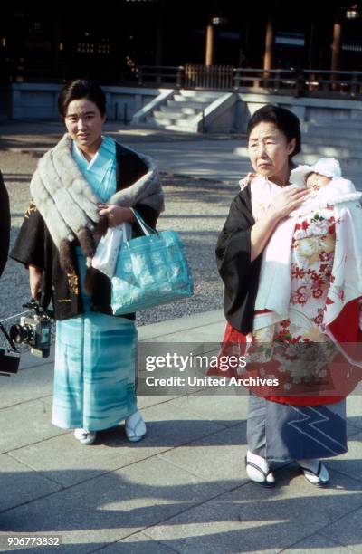 Mother and grandmother bringing a child to be baptised to Meiji shrine at Shibuya quarter in Tokyo, Japan 1960s.