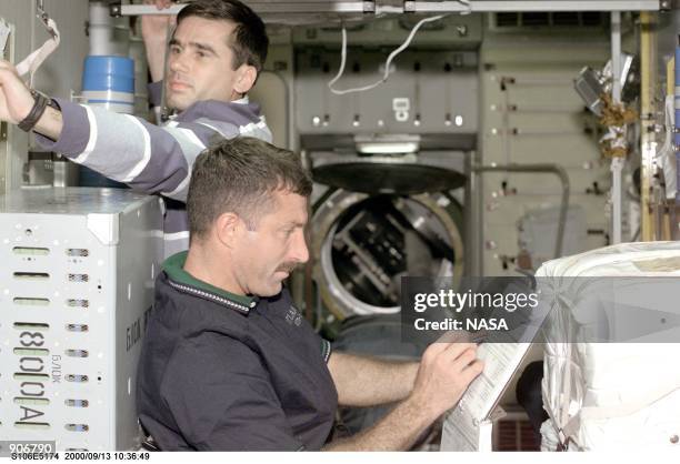 Cosmonaut Yuri I. Malenchenko, top, representing the Russian Aviation and Space Agency, and astronaut Daniel C. Burbank are part of the team effort...