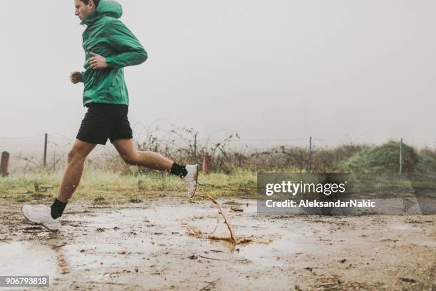 runner in action - puddle stock pictures, royalty-free photos & images