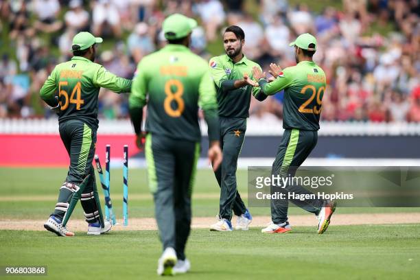 Faheem Ashraf of Pakistan celebrates with Sarfraz Ahmed and Shadab Khan after taking the wicket of Ross Taylor of New Zealand during game five of the...