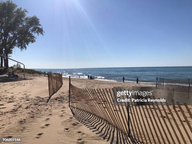 sunday’s shine down on people and a long, curved wooden fence in the afternoon. - saint joseph fotografías e imágenes de stock