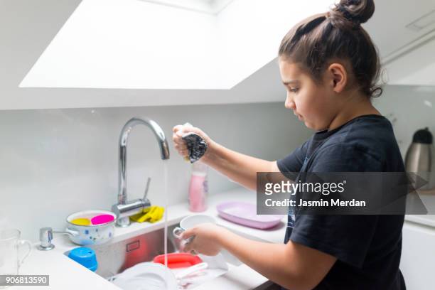 Boy washes dishes in the kitchen