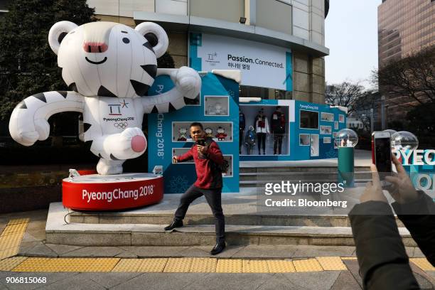 Tourist takes a selfie photograph in front of a statue of the 2018 PyeongChang Winter Olympic Games mascot Soohorang outside an Olympic official...