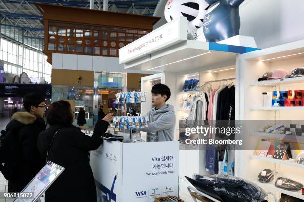 An employee, right, assists customers at an 2018 PyeongChang Winter Olympic Games official store inside Seoul Station in Seoul, South Korea, on...