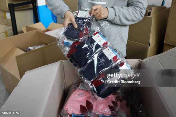 An employee arranges Olympic souvenir gloves at an 2018 PyeongChang Winter Olympic Games official store inside Seoul Station in Seoul, South Korea,...