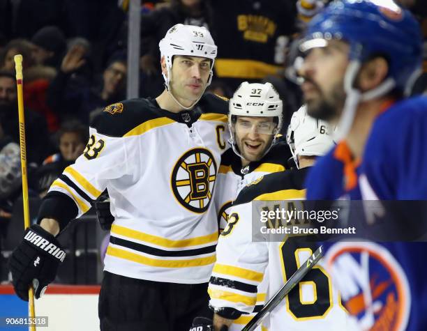 Patrice Bergeron of the Boston Bruins celebrates his hattrick at 3:45 of the third period against the New York Islanders and is joined by Zdeno Chara...