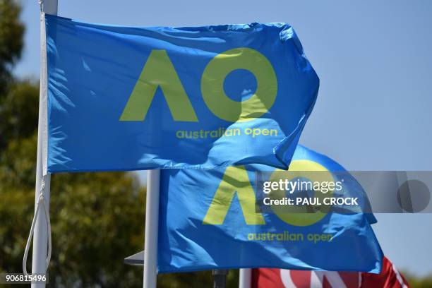 Australian Open flags flutter in the wind on day five of the Australian Open tennis tournament in Melbourne on January 19, 2018. / AFP PHOTO / Paul...