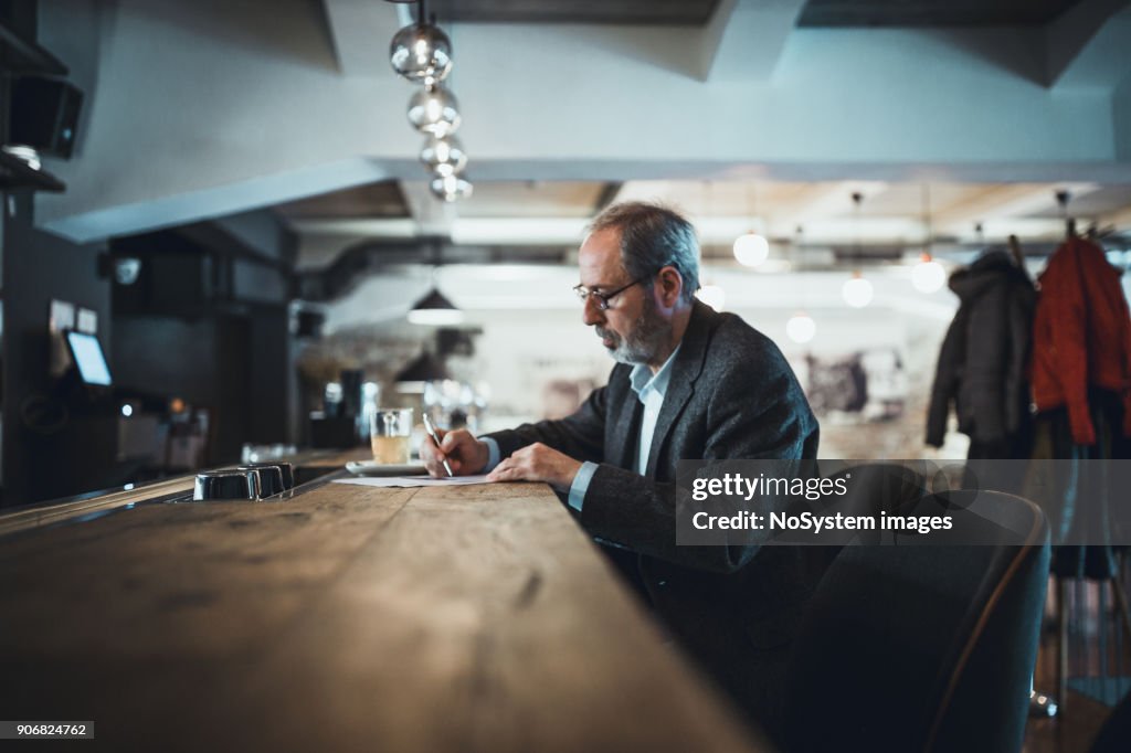 Co-Working Space in High-End Restaurants. Senior businessman with beard working in high end restaurant