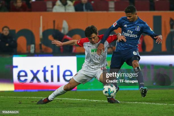 Ja-Cheol Koo of Augsburg and Douglas Santos of Hamburg battle for the ball during the Bundesliga match between FC Augsburg and Hamburger SV at...