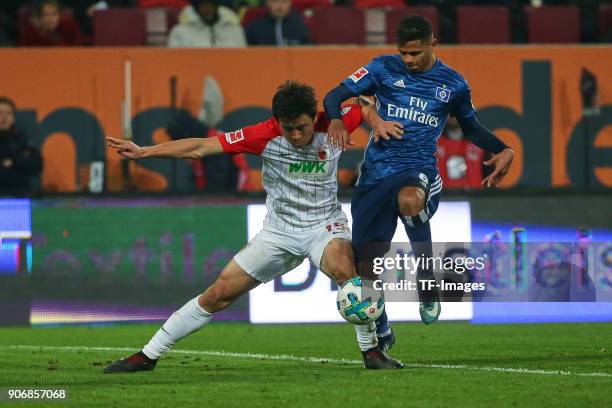 Ja-Cheol Koo of Augsburg and Douglas Santos of Hamburg battle for the ball during the Bundesliga match between FC Augsburg and Hamburger SV at...