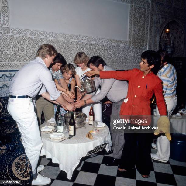 Before dining tourists are washing their hand in a Moroccan restaurant, Morocco 1980s.