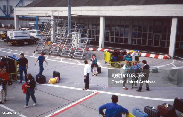 Passengers by the aifield at Frankfurt airport, Germany 1980s.