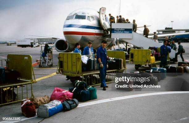 While their baggage is loaded, passengers enter their plane of the Jugoslowenski Aerotransport airline at Frankfurt airport, Germany 1980s.