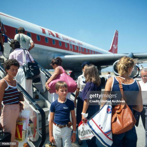 Passengers boarding to an airplane of the Spanish TAE airline, Germany 1980s.