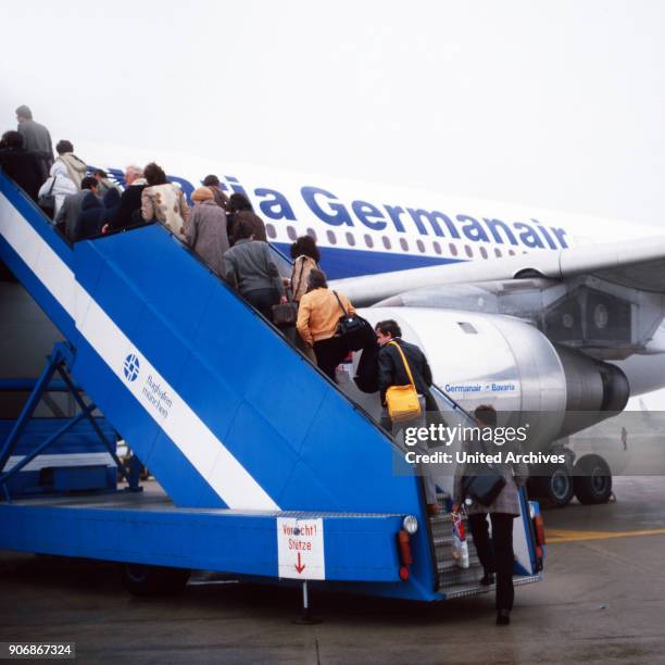 Passengers boarding a plane of Bavaria Germanair airline at Munich airport, Germany 1980s.