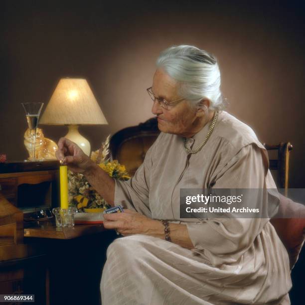 Senior woman with candle, 1980s.