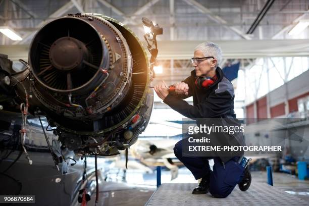 fluggerätmechaniker im hangar - flugzeugmechaniker stock-fotos und bilder