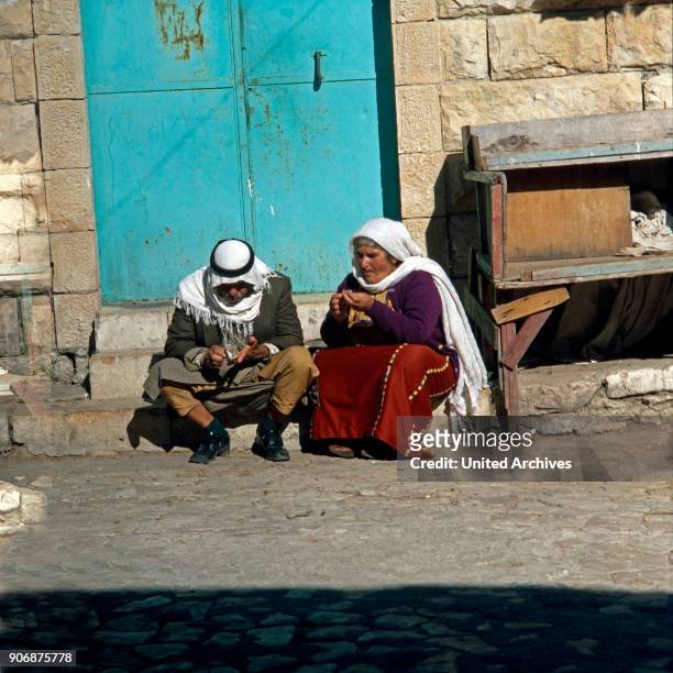 An elder couple sitting in front of the entrace to their house at Beer Sheba, Israel late 1970s.