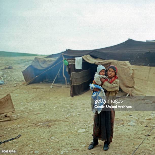 Young girl with a baby on her arms at a bedouin camp, Israel late 1970s.