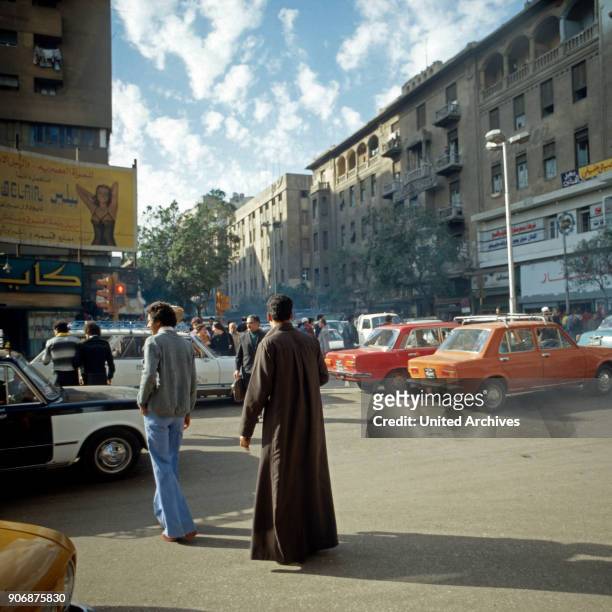 Passers by and traffic jam at the center of Cairo, Egypt, late 1970s.