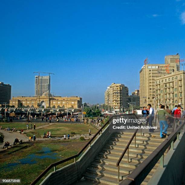 Midan al Tahrir square with the Egyptian Museum and Ramses Hilton Hotel under construction in the background, Cairo, Egypt, late 1970s.