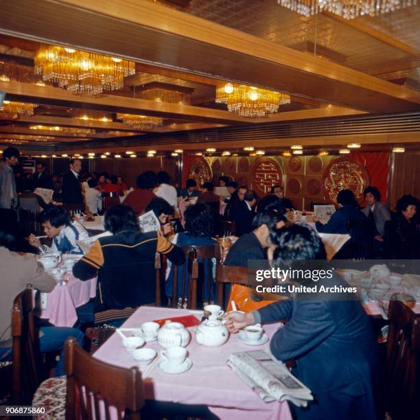 People having lunch at a restaurant in Hong Kong, early 1980s.