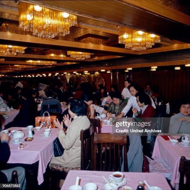 People having lunch at a restaurant in Hong Kong, early 1980s.