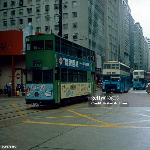 Tram and busses on their way through the streets of Hong Kong, early 1980s.