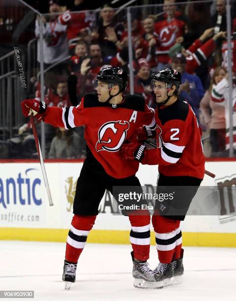 Taylor Hall of the New Jersey Devils is congratulated by teammate John Moore after Hall scored the game winning goal in overtime against the...