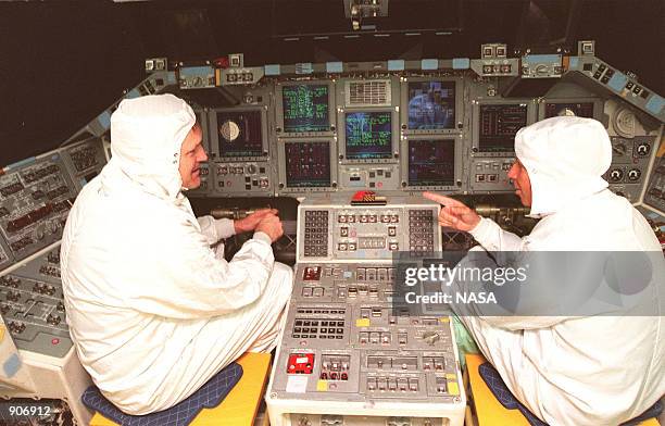 Commander James Halsell and STS-98 Commander Ken Cockrell look over the recently installed Multifunction Electronic Display Subsystem in the cockpit...