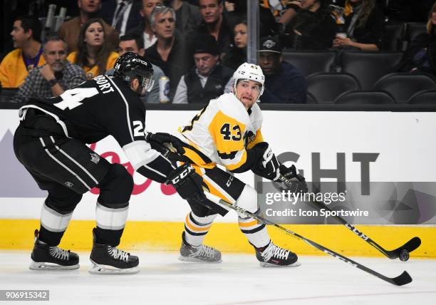 Pittsburgh Penguins Left Wing Conor Sheary looks to try and pass the puck around Los Angeles Kings Defenseman Derek Forbort during an NHL game...