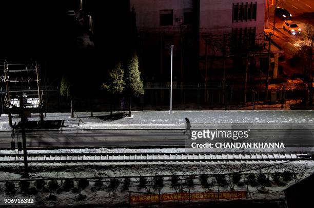 In this photograph taken on January 10, 2018 a Chinese soldier walks along railway tracks of the Friendship Bridge in the Chinese border city of...