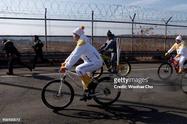 Torchbearer with 600 bike riders carry the torch by bicycle during the torch relay for PyeongChang 2018 Olympics on January 19, 2018 in Paju, South...