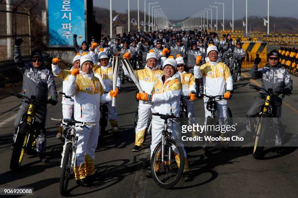 Torchbearers make torchkiss in front of 600 bike riders when they arrive at the entrance of the Unification Bridge which is the border of Civilian...