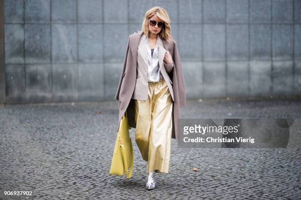Gitta Banko wearing golden paper trousers by MM6 Martin Margiela, silver blouse from H&M, shiny beige leather blazer by Dawid Tomaszewski, taupe...