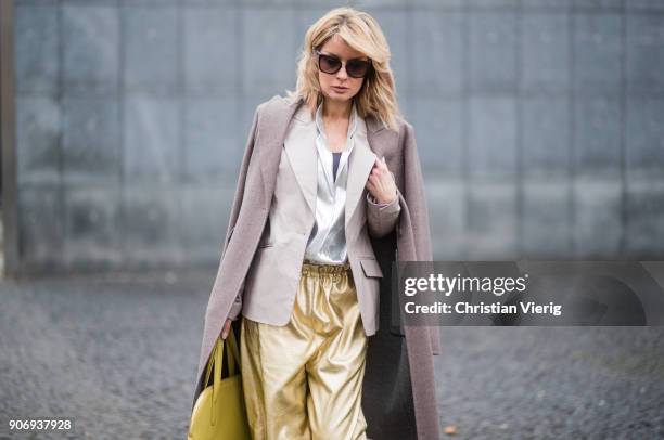 Gitta Banko wearing golden paper trousers by MM6 Martin Margiela, silver blouse from H&M, shiny beige leather blazer by Dawid Tomaszewski, taupe...