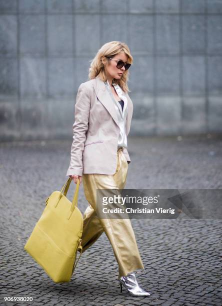 Gitta Banko wearing golden paper trousers by MM6 Martin Margiela, silver blouse from H&M, shiny beige leather blazer by Dawid Tomaszewski, taupe...