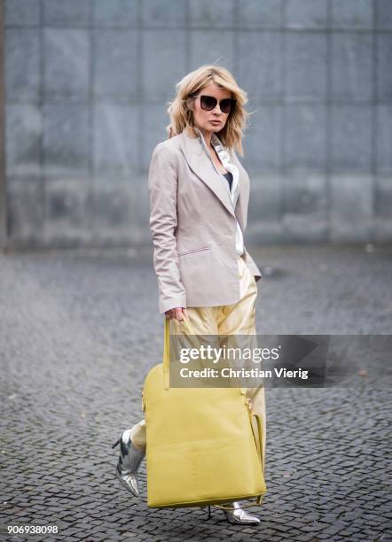 Gitta Banko wearing golden paper trousers by MM6 Martin Margiela, silver blouse from H&M, shiny beige leather blazer by Dawid Tomaszewski, taupe...